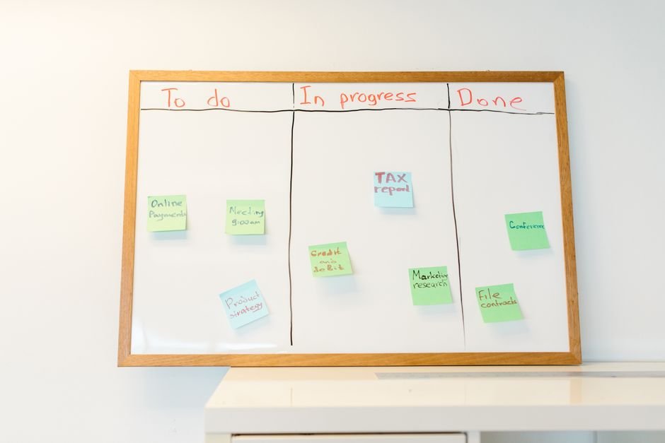Notion vs Asana project management comparison with kanban sticky notes on a whiteboard